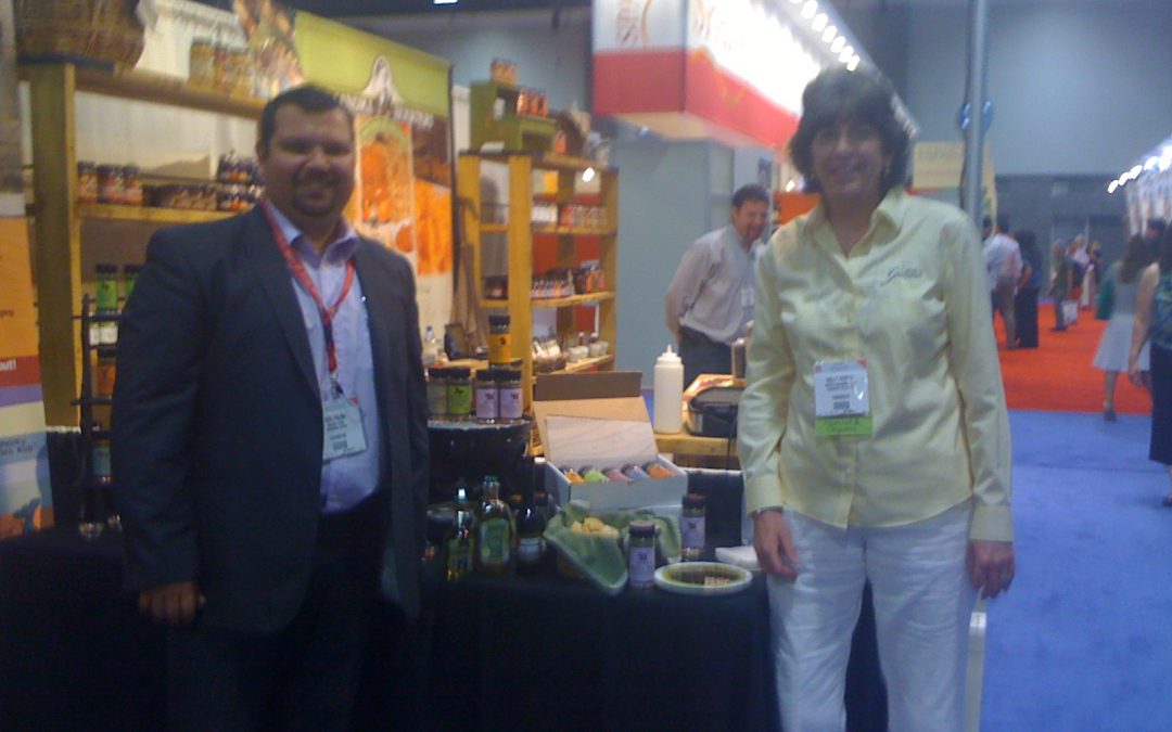 Two people at trade show booth displaying products