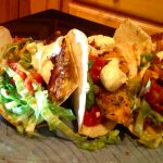 three fish tacos with lettuce and sauce